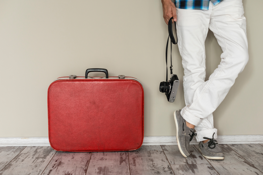 Young man standing by his luggage