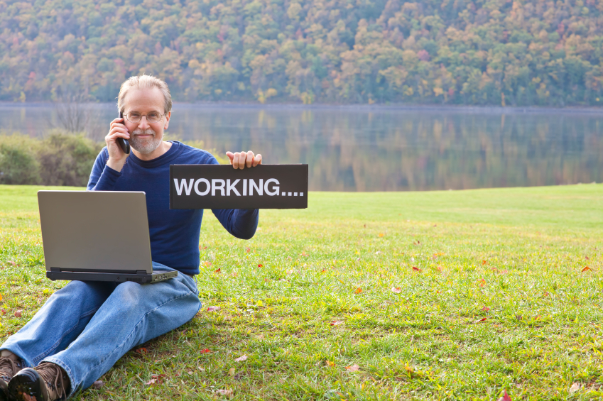 Middle aged matured man holding a working sign while talking on the phone