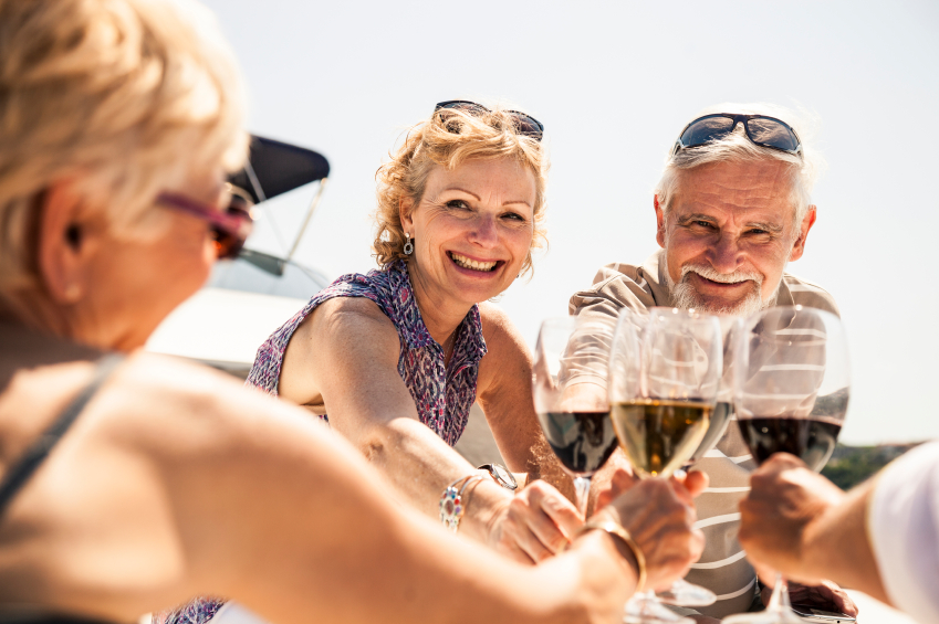 Group of senior friends drinking wine on a yacht