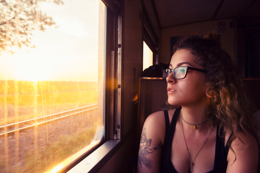 Young woman lady girl with tattoo looking out the window in a train