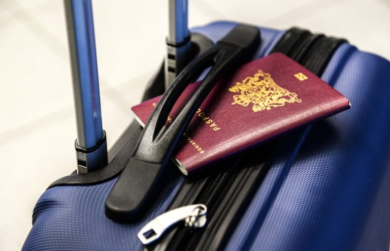 TILE UK passport Passport sitting on top of a blue roller suitcase